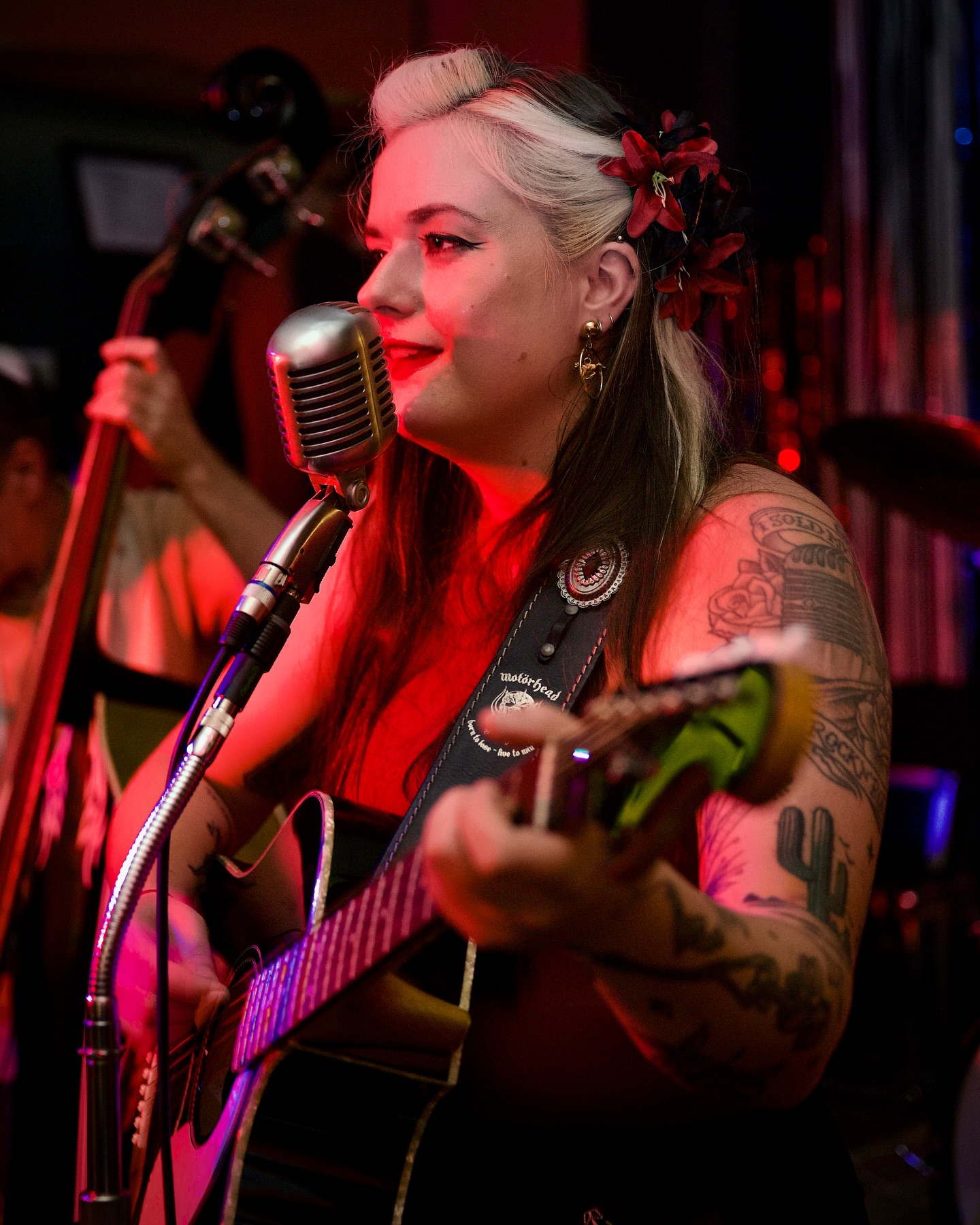 Britt Bones performing with vintage microphone under red stage lights