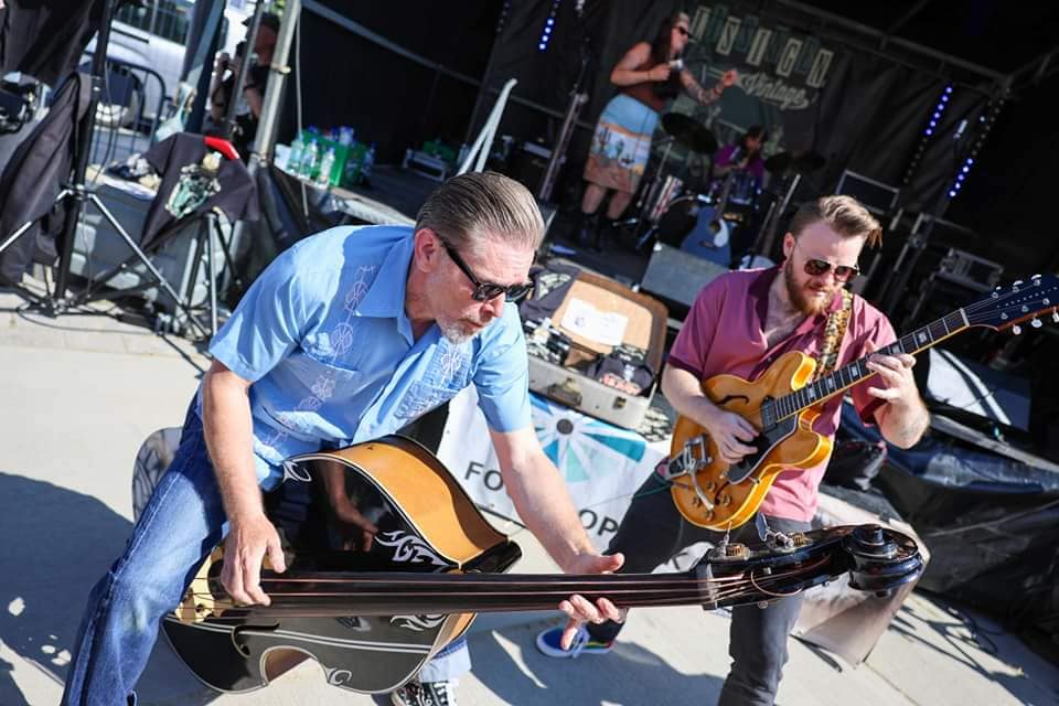 Outdoor daytime performance with bass and guitar players